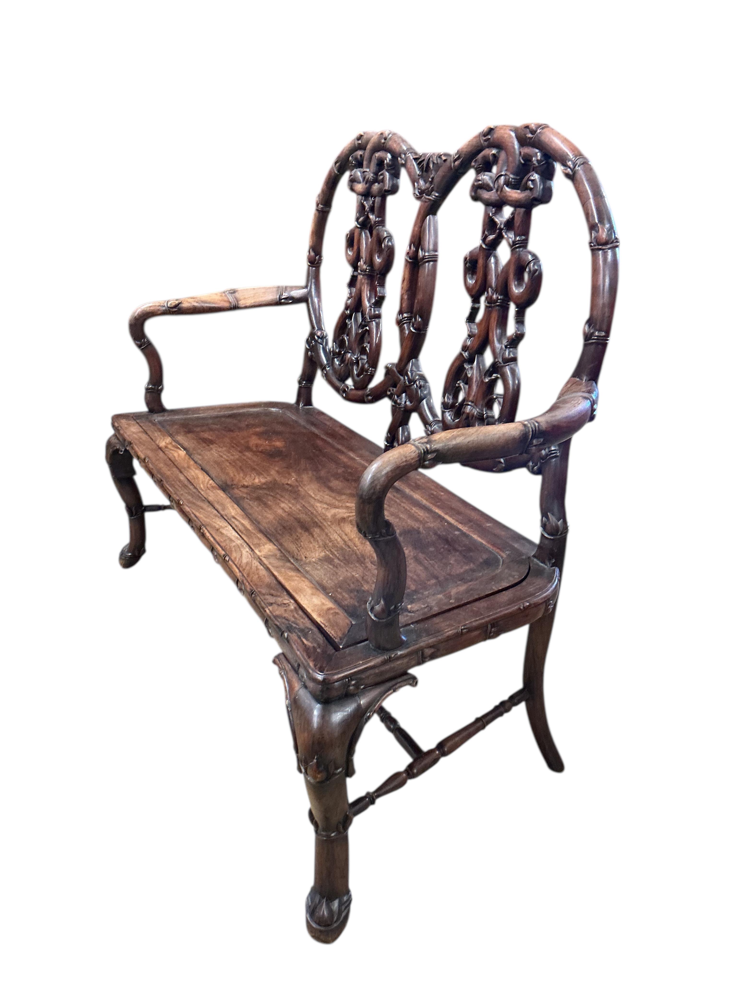 A 19th century Chinese carved hardwood chair back settee, width 116cm, depth 46cm, height 102cm